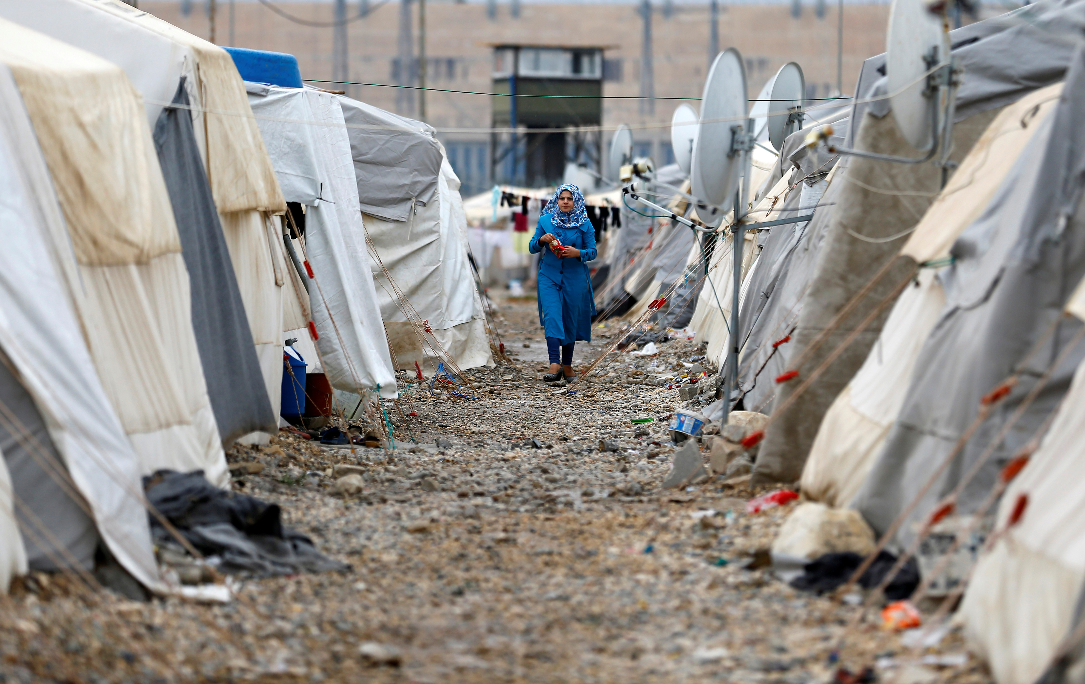 A Syrian refugee woman walks between tents in the Nizip refugee camp, near the Turkish-Syrian border in the Gaziantep province of Turkey on November 30, 2016. Source: Umit Bektas/Reuters.