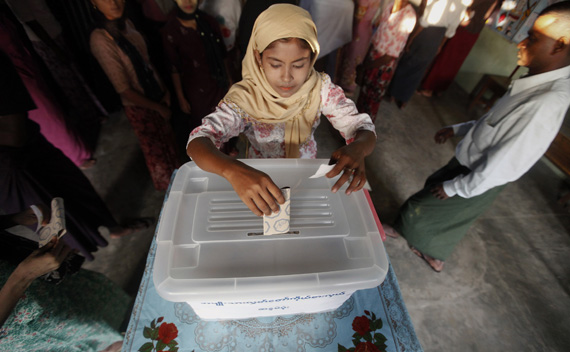 A woman casts her ballot at the polling station in Sittwe