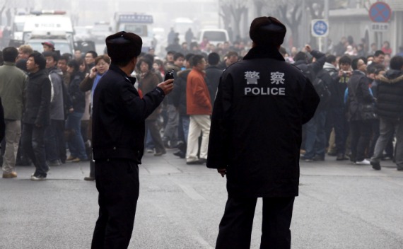 Policemen watch a crowd that gathered outside a McDonald’s restaurant after internet social networks called for a