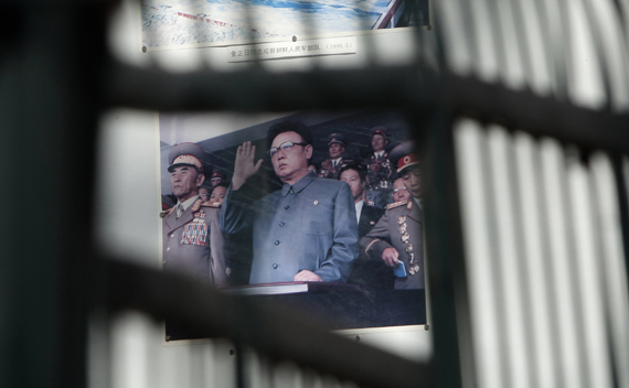 A billboard depicting North Korean leader Kim Jong-il is seen through the fence of the North Korea embassy in Beijing January 21, 2011. 