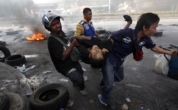 A man is dragged after being shot at Rama IV Street during clashes between army soldiers and anti-government ’red shirt’ supporters in Bangkok May 15, 2010.