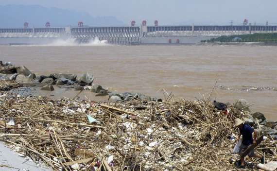 A worker clears floating garbage on the Yangtze River near the Three Gorges Dam in Yichang, Hubei province on August 1, 2010.