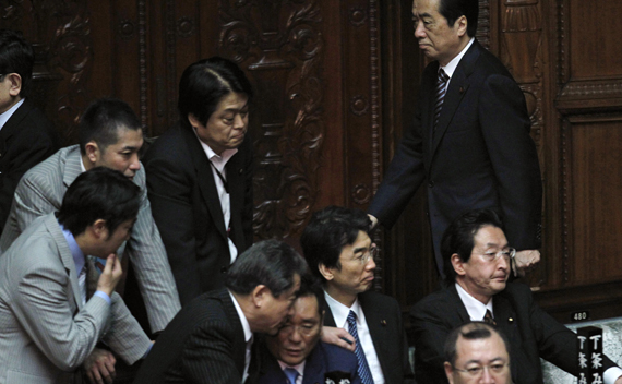 Japan’s Prime Minister Naoto Kan (R) walks past lawmakers to cast a vote against the opposition-sponsored no-confidence motion in parliament in Tokyo June 2, 2011. Kan survived a no-confidence vote in parliament on Thursday, but the unpopular leader will still struggle to break a policy deadlock given a split in his own party and a divided parliament.
