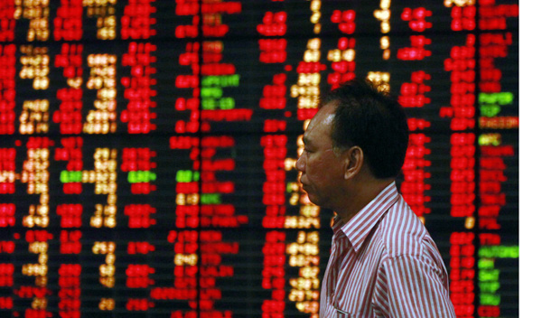 A Thai investor walks past an electronic board displaying live market data at a stock broker’s office in central Bangkok August 9, 2011.