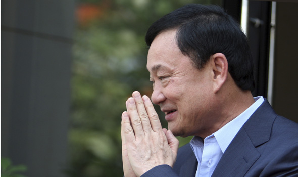 Thailand’s former premier Thaksin Shinawatra greets journalists outside his home in Dubai.