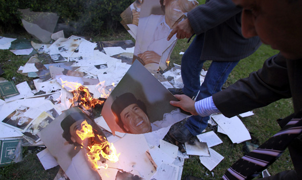 Employees of the Libyan Embassy burn portraits of Libyan leader Muammar Gaddafi at the embassy’s garden in Buenos Aires August 23, 2011.