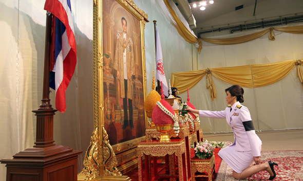 Thailand’s first female PM Yingluck Shinawatra receives the royal command appointing her as the country’s new premier in front of a portrait of Thai King Bhumibol Adulyadej in Bangkok.