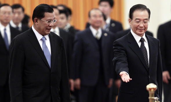 China’s Premier Wen shows the way to Cambodia’s PM Sen during a welcome ceremony in Beijing.