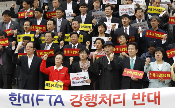 Lawmakers from opposition parties and civic group members chant slogans during a rally opposing the U.S.-South Korea Free Trade agreement (FTA) talks at the National Assembly in Seoul October 12, 2011.