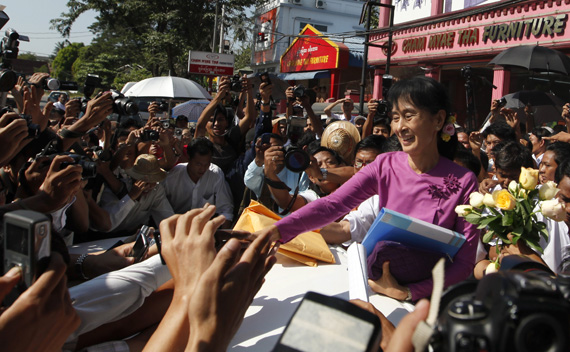 Myanmar democracy leader Aung San Suu Kyi shakes hands with people outside the National League for Democracy (NLD) head office after a meeting in Yangon November 18, 2011.