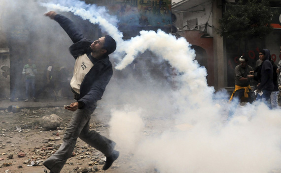 A protester throws a tear gas canister, which had earlier been thrown by riot police, near Tahrir Square in Cairo November 20, 2011.