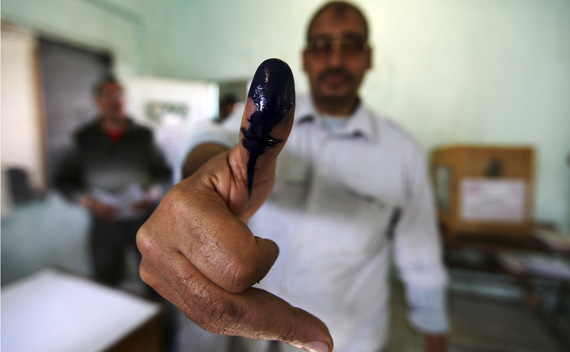 A man shows his ink stained finger after casting his vote at a polling station during parliamentary elections in Cairo November 28, 2011.