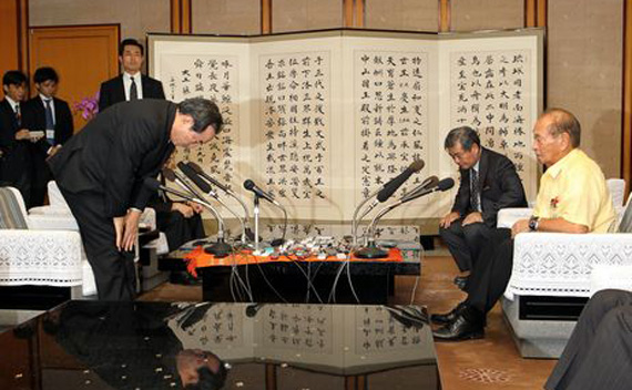 Defense Minister Yasuo Ichikawa, left, apologizes to Okinawa Governor Hirokazu Nakaima December 2, 2011 (Tadashi Mizowaki/Courtesy to the Asahi Shimbun)