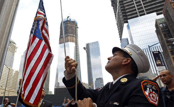 New York Fire Department Battalion Commander Tom Currao raises a flag outside the World Trade Center construction site at the 9/11 Memorial Visitors Center in New York September 9, 2011. The flag, which flew overseas during Operation Enduring Freedom, was accepted by museum curators into their collection. National and city leaders will commemorate on Sunday the ten-year anniversary of the attacks of September 11, 2001 with a ceremony unveiling a memorial and museum. REUTERS/Brian Snyder
