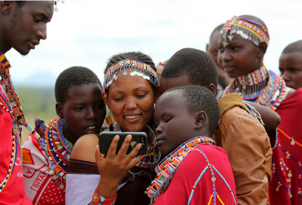 Maasai girls watch a video on a mobile phone prior to the start of an event advocating against harmful traditional practices in Imbirikani, Kenya, April 21, 2016. In Kenya, as in many countries around the world, national statistical systems have been ill-equipped and under-funded to collect data on ethnic minorities, rural communities, and indigenous populations. REUTERS/Siegfried Modola