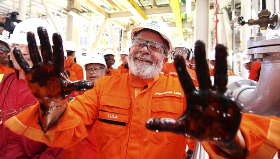 Brazil’s President Luiz Inacio Lula da Silva holds up his oil-covered hands at the Cidade Angra dos Reis offshore platform.