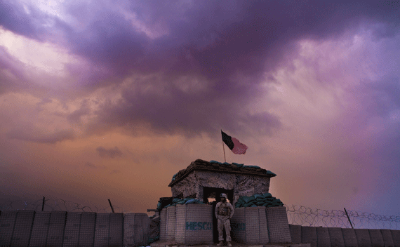 A U.S. Marine watches an evening storm gather above an outpost in Helmand province.