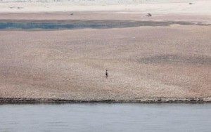 A boy runs on a dried up reservoir on the Mekong River during a drought affecting the Thai-Lao border area of Wiang Kaen district
