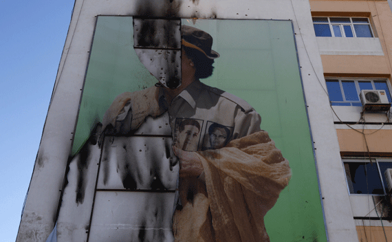 A damaged poster of ousted Libyan leader Muammar Gaddafi is seen in Tripoli September 7, 2011. Picture taken September 7, 2011. REUTERS/Anis Mili