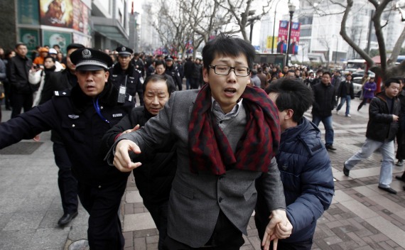 A man is arrested by police in front of the Peace Cinema, where internet social networks were calling to join a