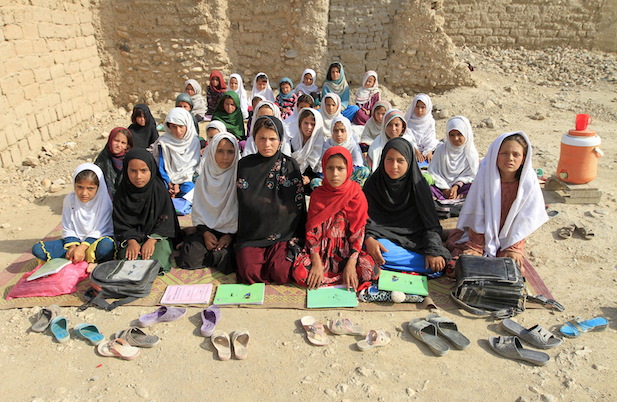Teacher Mahajera Armani and her class of girls pose for a picture at their study open area, founded by Bangladesh Rural Advancement Committee (BRAC), outside Jalalabad city, Afghanistan September 19, 2015. Nearly three years after Taliban gunmen shot Pakistani schoolgirl Malala Yousafzai, the teenage activist last week urged world leaders gathered in New York to help millions more children go to school. World Teachers’ Day falls on 5 October, a Unesco initiative highlighting the work of educators struggling to teach children amid intimidation in Pakistan, conflict in Syria or poverty in Vietnam. Even so, there have been some improvements: the number of children not attending primary school has plummeted to an estimated 57 million worldwide in 2015, the U.N. says, down from 100 million 15 years ago. (Courtesy Reuters/Parwiz)