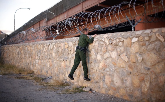 A U.S. Border Patrol agent checks an area under a bridge crossing between the United States and Mexico (Eric Thayer/Courtesy Reuters).