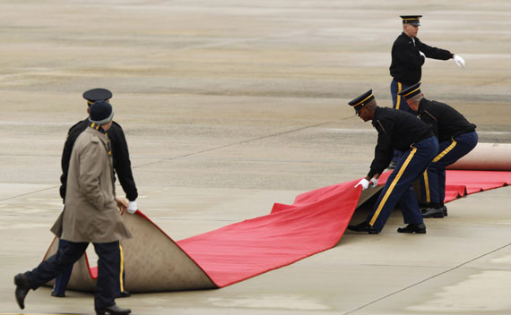 U.S. Air Force personnel adjust the red carpet before the arrival of China’s President Hu Jintao at Andrews Air Force Base.