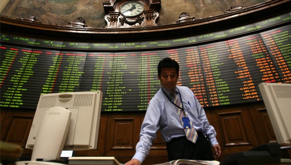 A trader checks a newspaper at the Santiago Stock Exchange (Ivan Alvarado/Courtesy Reuters)
