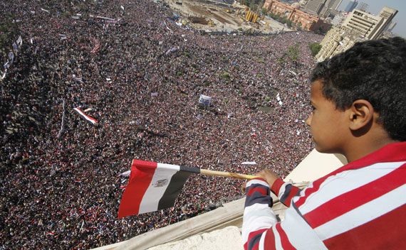 A boy watches as pro-democracy supporters gather in Tahrir Square in Cairo on February 18, 2011.