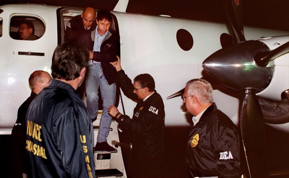 U.S. Drug Enforcement Administration agents usher Fabio Ochoa, Colombian drug kingpin, to an awaiting vehicle following his extradition from Colombia to  Florida, September 8, 2001(Courtesy Reuters).