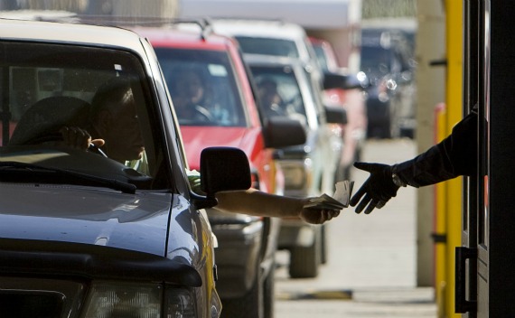 A customs officer is handed a passport by a motorist at the San Ysidro border crossing (Fred Greaves/Courtesy Reuters).