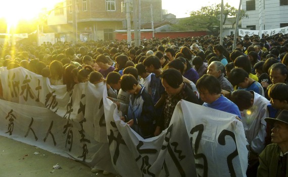 Residents observe a moment of silence for a local leader who died in police custody, during a demonstration in Wukan village on December 13, 2011.