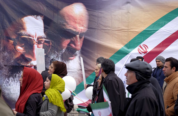 People walk past a large picture of the late leader of the Islamic Revolution Ayatollah Ruhollah Khomeini (R) and Iran’s Supreme Leader Ayatollah Ali Khamenei, during a ceremony marking the 37th anniversary of the Islamic Revolution, in Tehran February 11, 2016. 