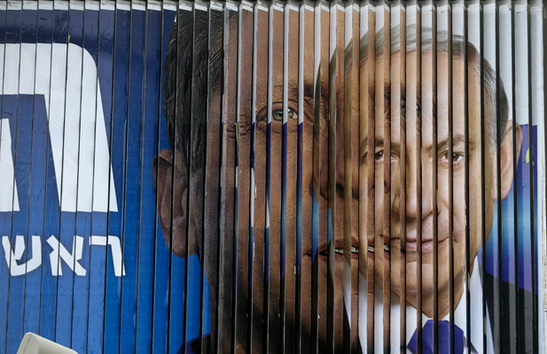 Israeli Prime Minister Benjamin Netanyahu (R) and Isaac Herzog, Co-leader of the centre-left Zionist Union, are pictured together as campaign billboards rotate in Tel Aviv