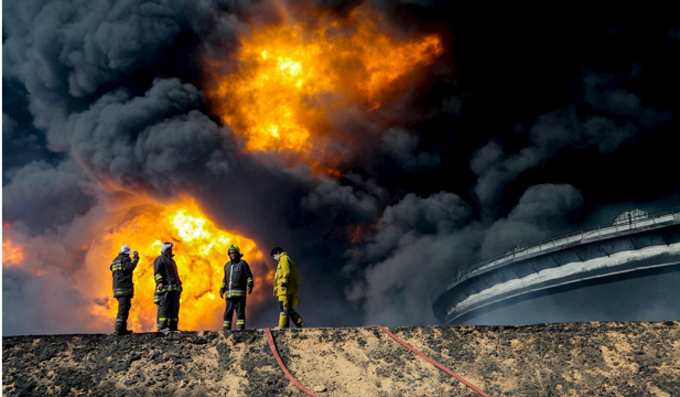 Firefighters try to put out the fire in an oil tank in the port of Es Sider, in Ras Lanuf, Libya January 6, 2016. Firefighters have extinguished two fires at oil storage tanks at Libya’s Ras Lanuf terminal, but blazes continue at five tanks in the nearby port of Es Sider after attacks this week by Islamic State militants, a Petroleum Facilities Guards (PFG) spokesman said on Thursday