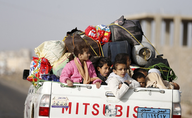 Children ride on the back of a pick-up truck with their luggage as they flee Saudi-led air strikes in Sanaa April 6, 2015.