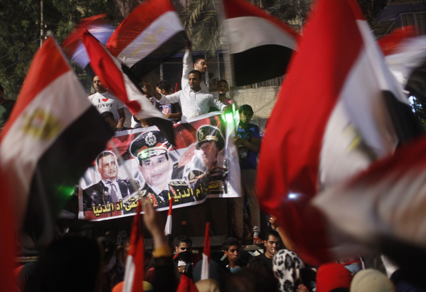 Protesters cheer with Egyptian flags and a banner of army chief Abdel-Fattah El-Sisi.