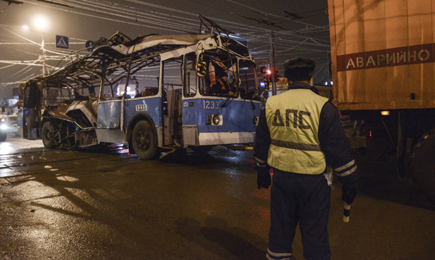 A policeman watches as a bus, destroyed in an earlier explosion, is towed away in Volgograd December 30, 2013.