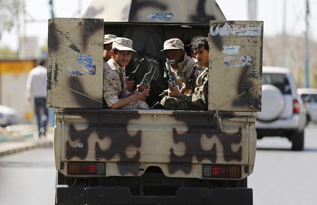 Houthi fighters ride a patrol vehicle outside a hotel hosting UN-sponsored negotiations on a political settlement for Yemen’s crisis in Sanaa, February 19, 2015.