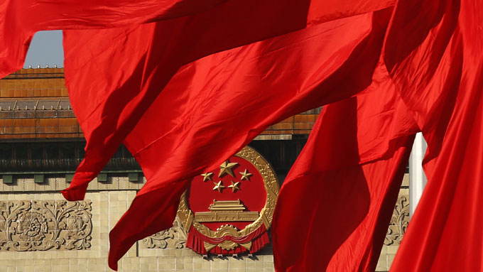 The Great Hall of the People is seen behinds red flags in Tiananmen square in Beijing, November 12, 2013.