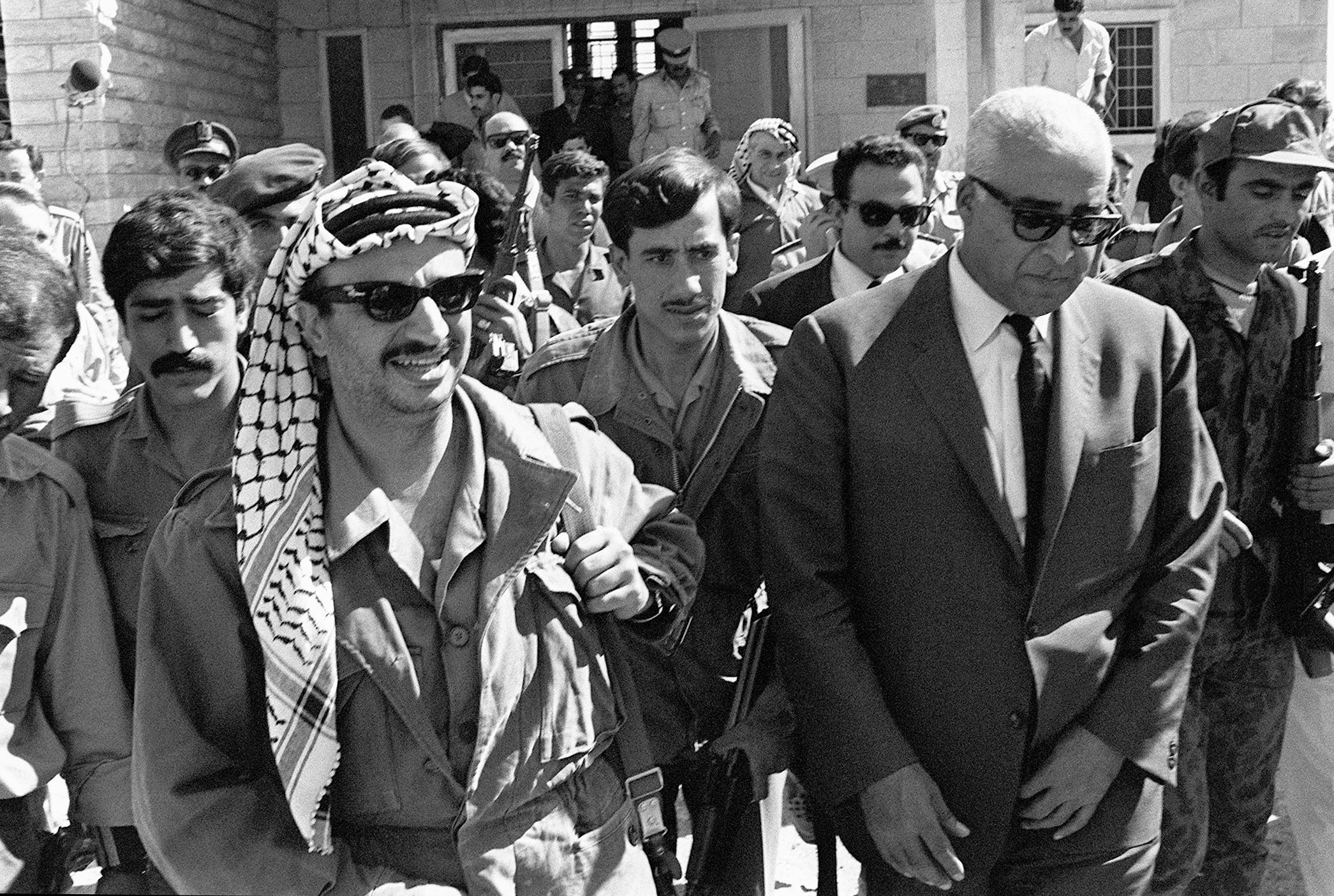 Yasir Arafat walks with Jordanian official Bahi Lagdham in October 1970.