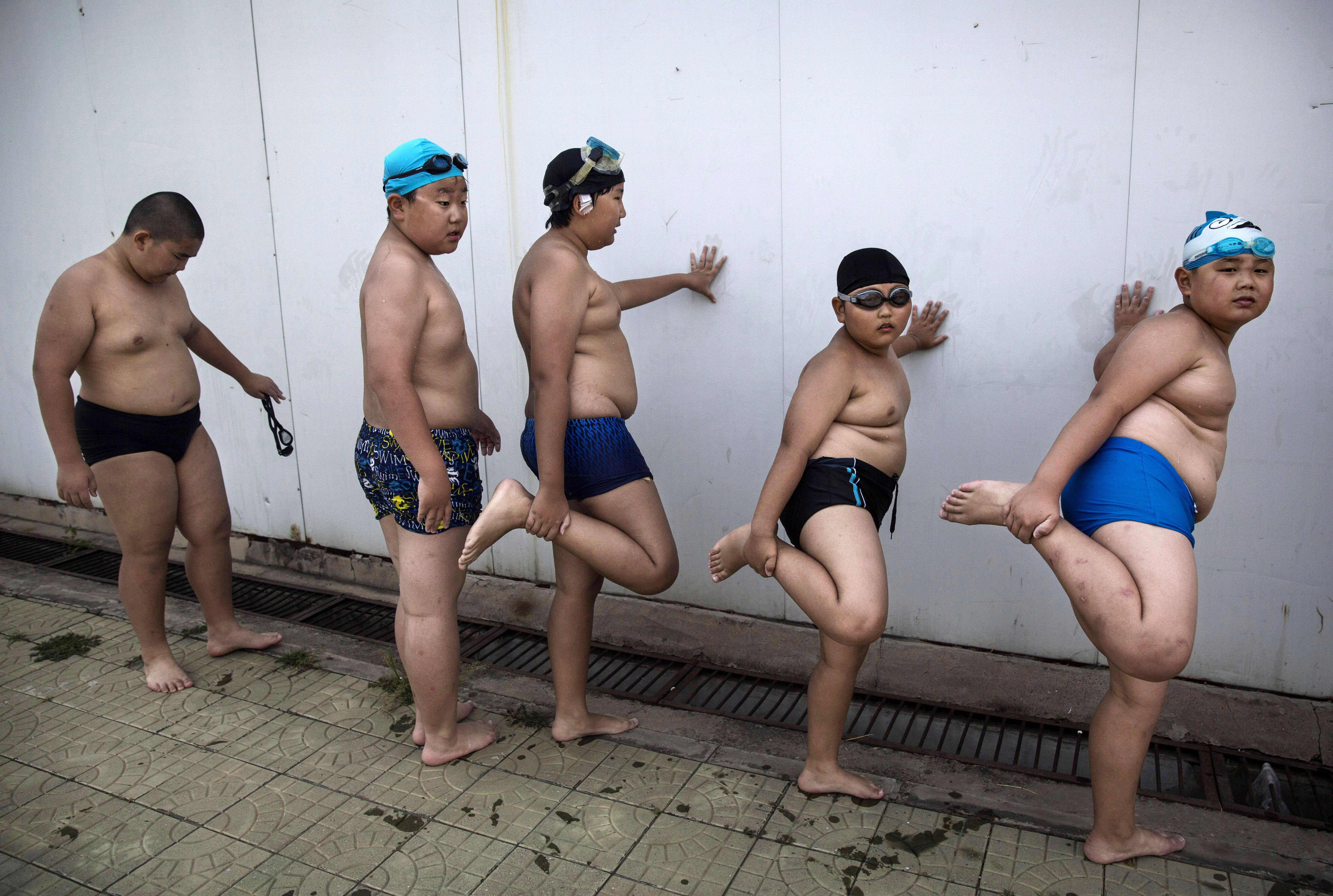 Chinese students stretch for swimming in Beijing. More investment is needed to prevent and reduce the unhealthy lifestyles that spur NCDs, but few countries, poor or wealthy, have managed to lower health risks such as childhood obesity