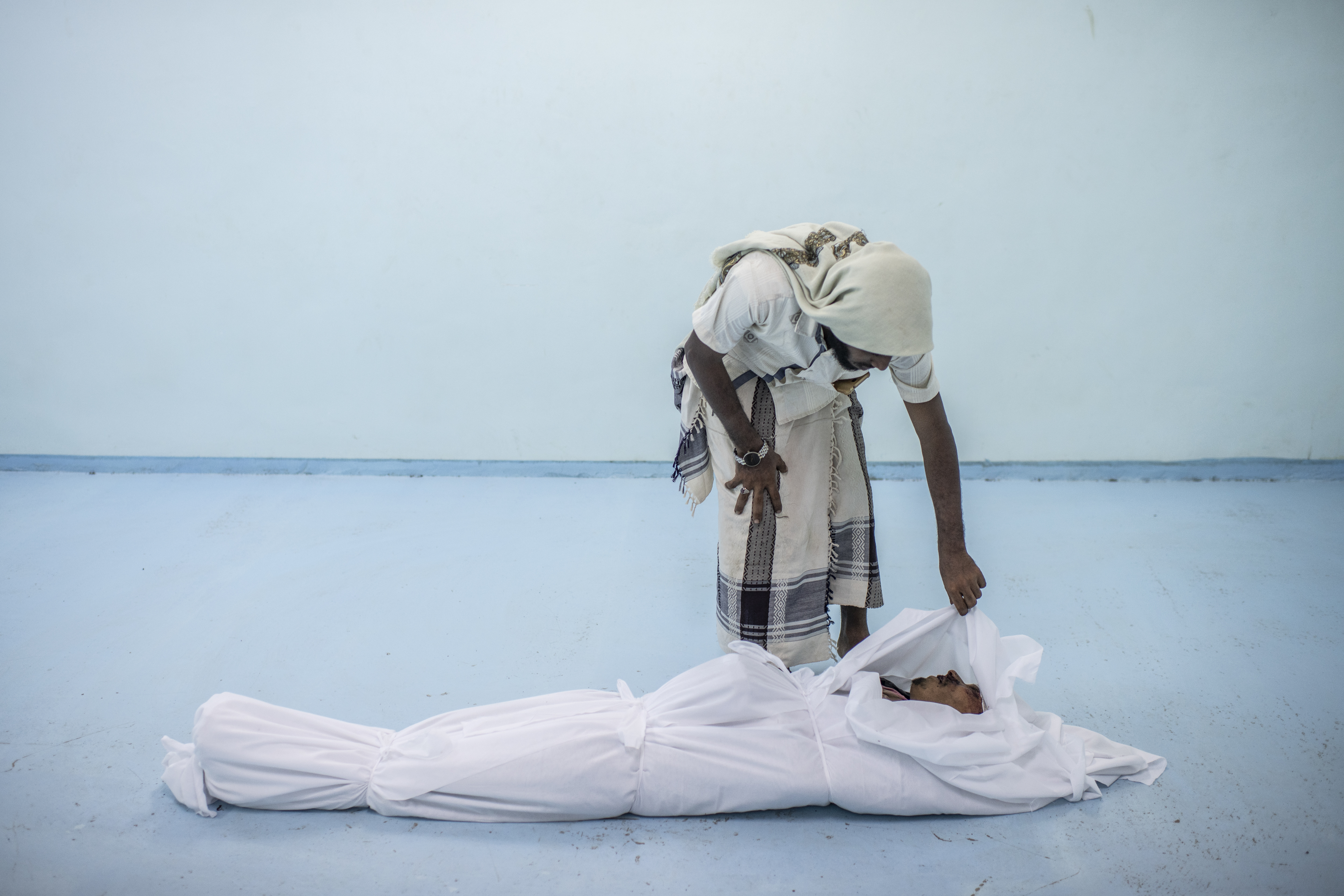 A combatant killed in Hodeidah is attended to at the morgue of a field hospital.