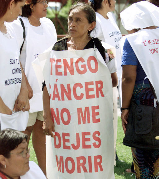 A group of protesters stand outside the World Trade Organization ministerial meeting venue in Cancun, September 10, 2003. The sign reads: 