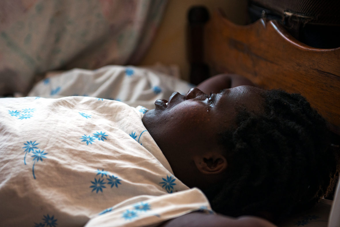 Barbara Namigadele, 36, lies in her home in an advanced stage of breast cancer in Kampala, Uganda. Like many women with breast cancer in Uganda, it took her months to see a doctor and raise the money for her treatment. 