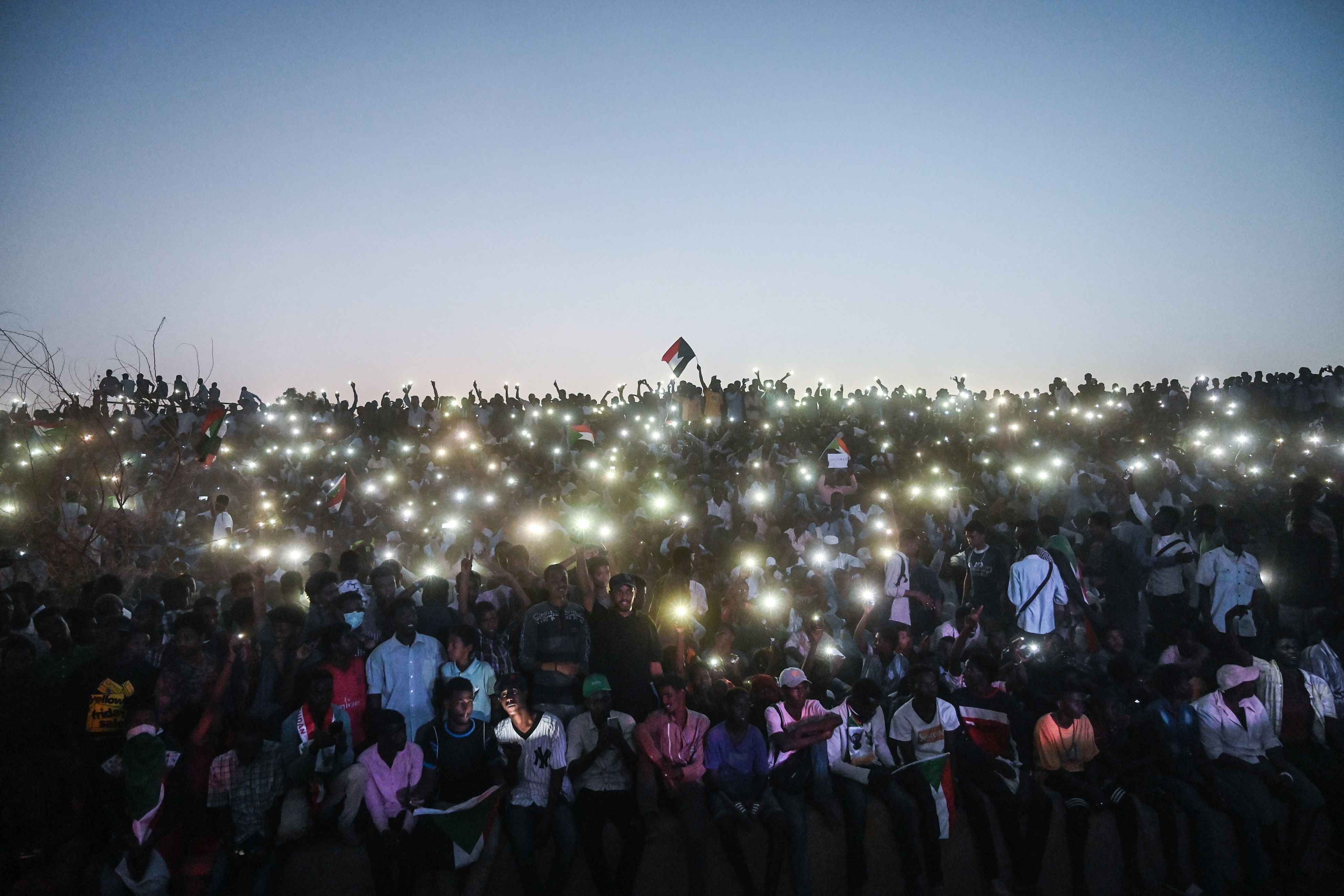  Sudanese protesters open their smartphones lights as they gather for a 