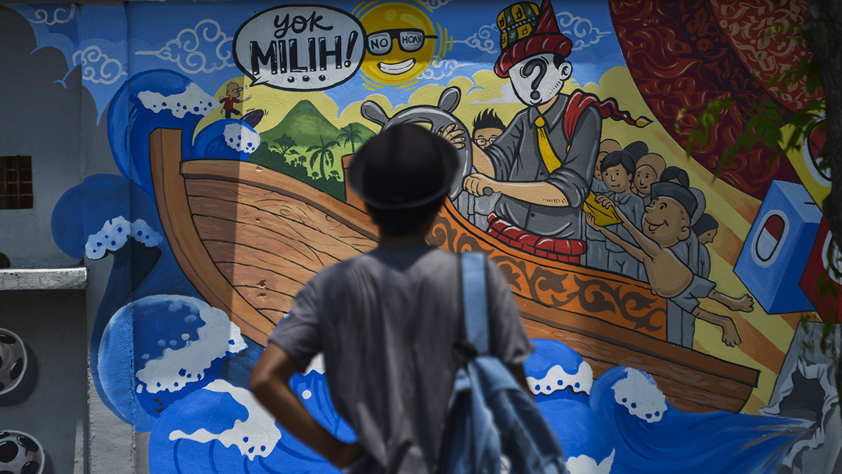 A man looks at a campaign mural in Banda Aceh, Indonesia, ahead of April’s elections.