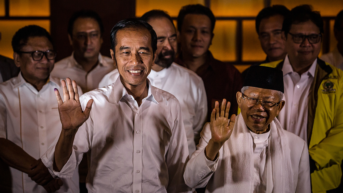 President Joko Widodo and his vice presidential candidate Maruf Amin (R) wave during a press conference after Indonesia’s election.