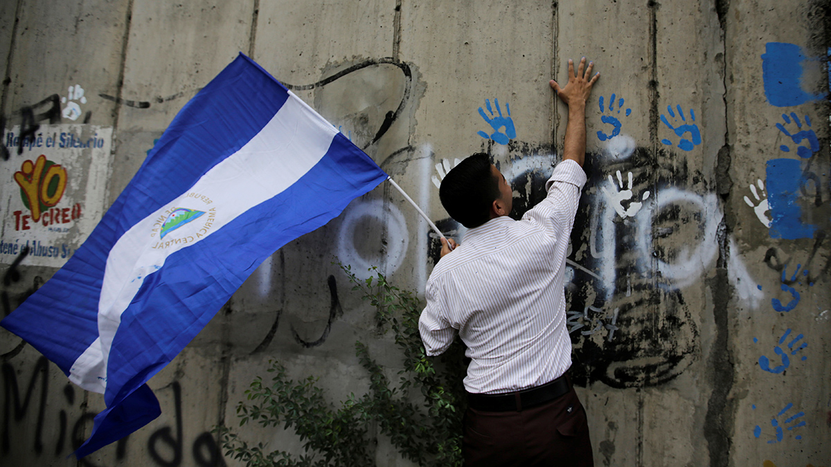A demonstrator places his painted handprints on a wall during a gathering to mark one hundred days of anti-government protests aimed to oust Nicaragua's President Daniel Ortega, in Managua. 