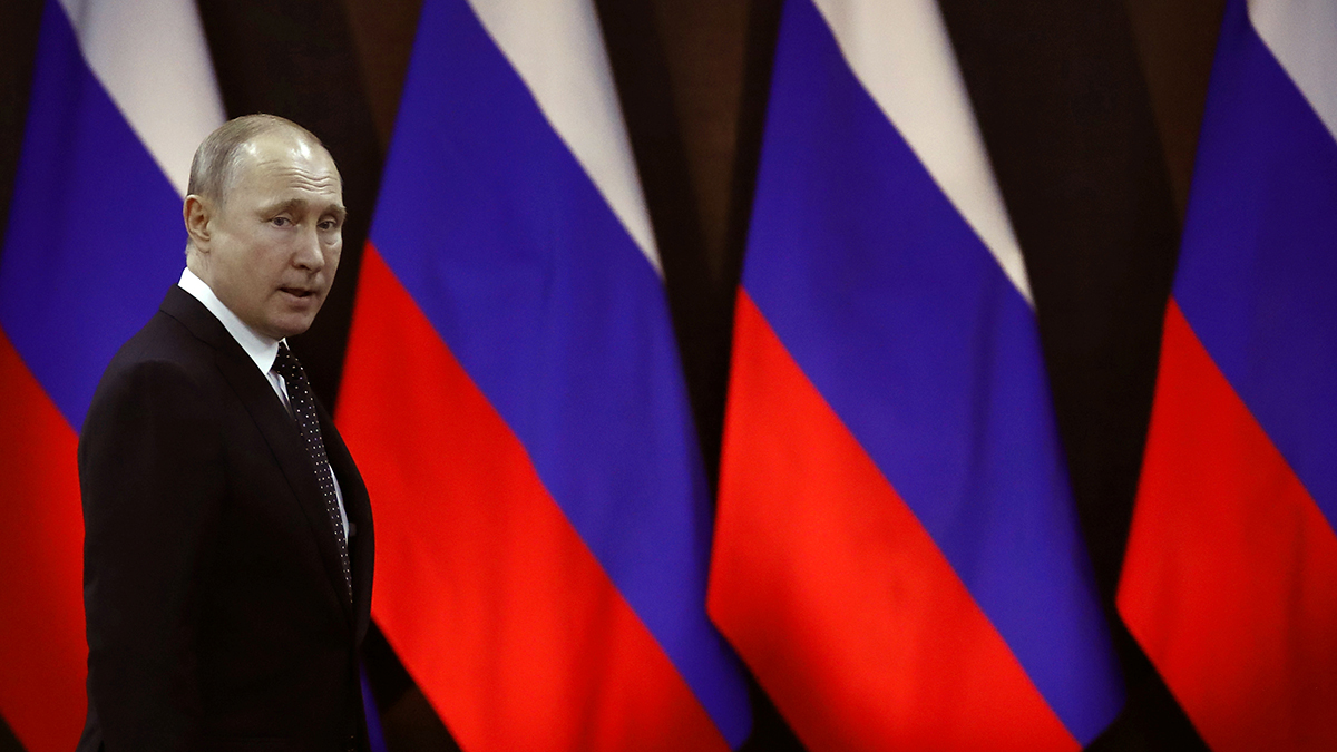 Russian President Vladimir Putin walks past Russian flags in April 2019.